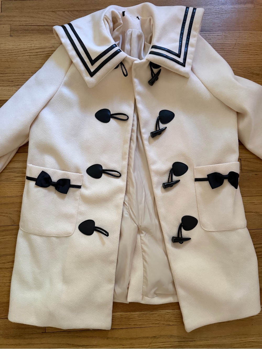 Cream Toggle-Front Coat with Black Trim and Bows